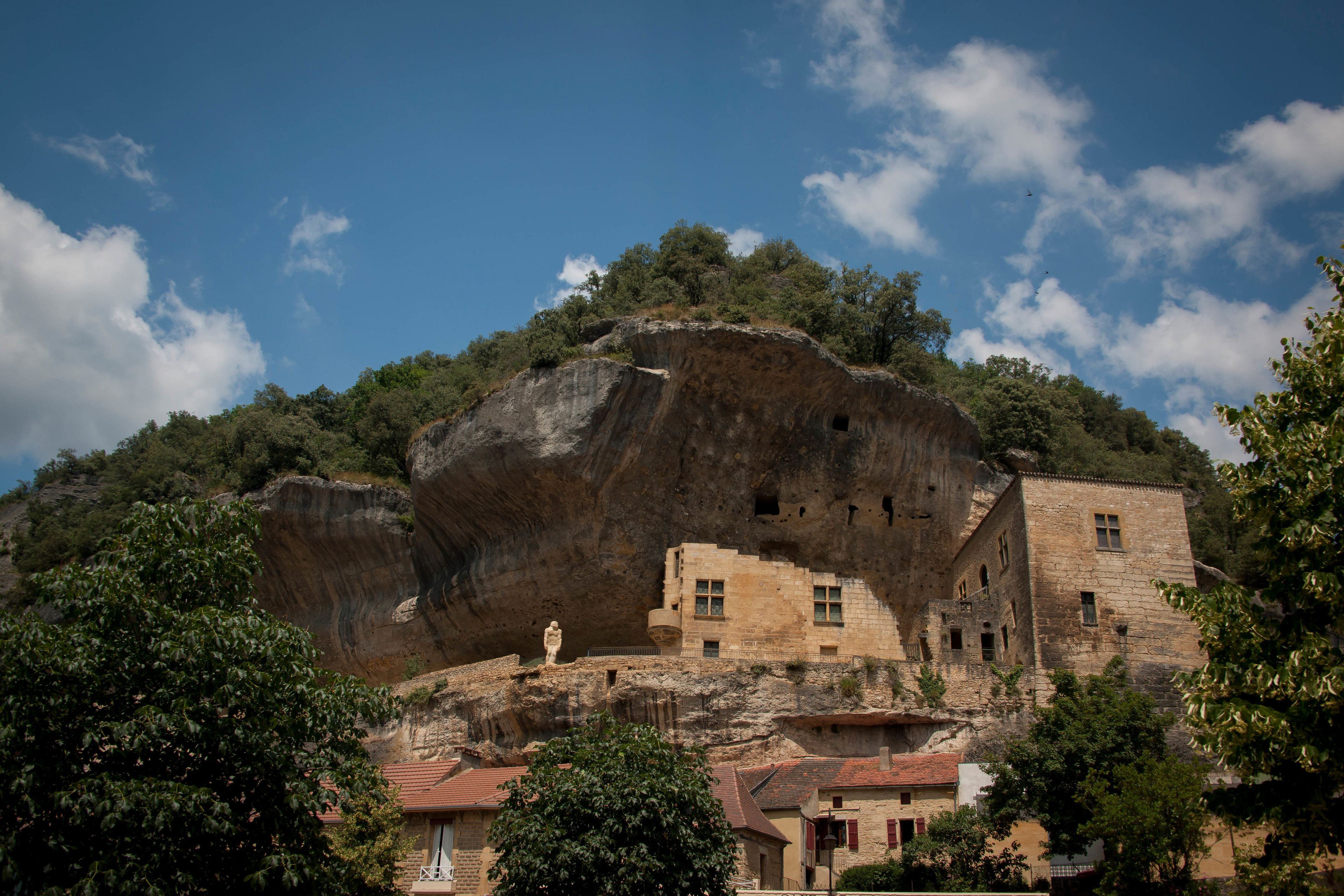 A historic building with stone architecture, situated on a cliff with a view of the surrounding landscape.