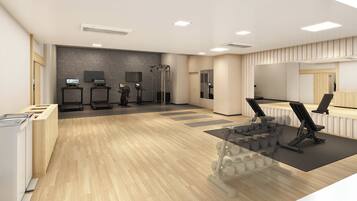 A modern fitness center with treadmills, exercise bikes, and a mirrored wall.