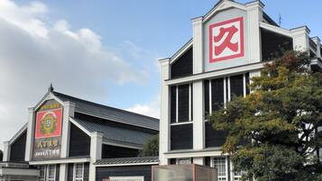 A building with a large red square sign on the top right, a smaller sign with Chinese characters on the left, and a black gate in the center.