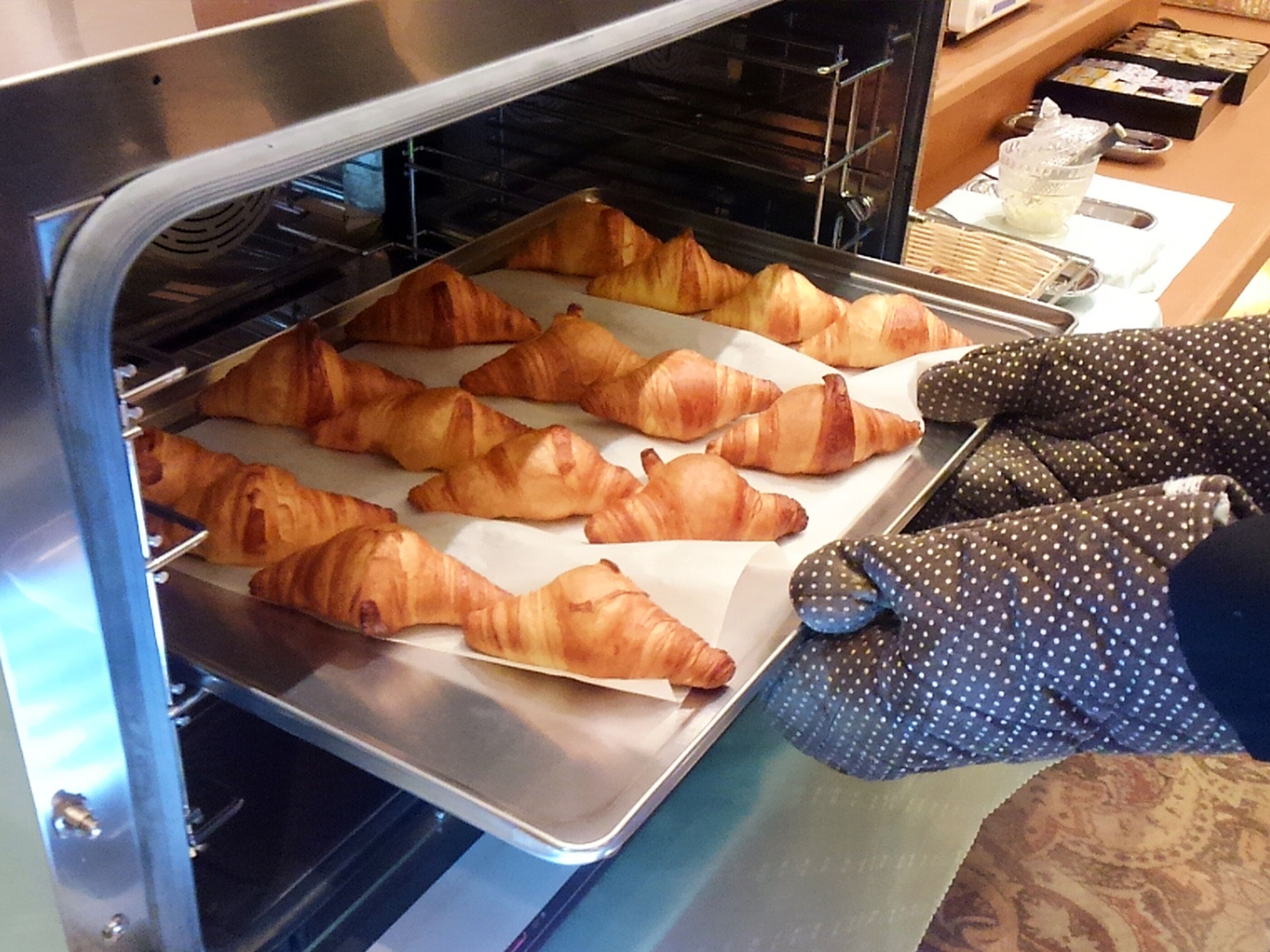 Una panadería con cruasanes en un horno.