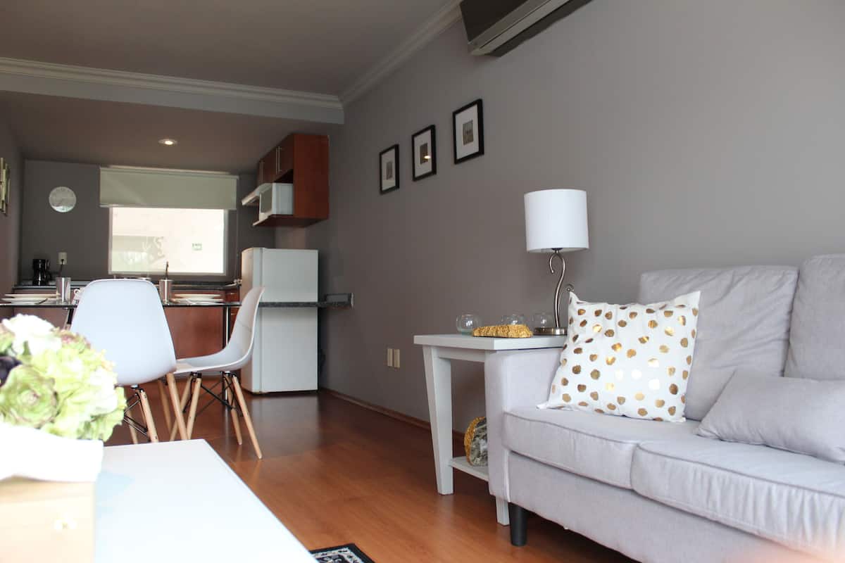 Relax in this inviting living area with a sofa, dining table, and modern kitchen.