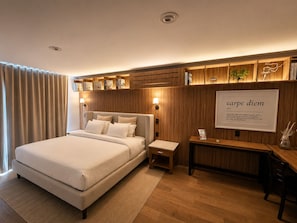 A modern bedroom with a large bed, bedside tables, a desk, and a wall-mounted shelf with books. - Residence L'heritage Hipólito Taine by Bluebay (Mexico City)