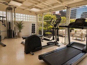 A gym with exercise equipment, a treadmill, and a view of the outdoors. - Residence L'heritage Hipólito Taine by Bluebay (Mexico City)
