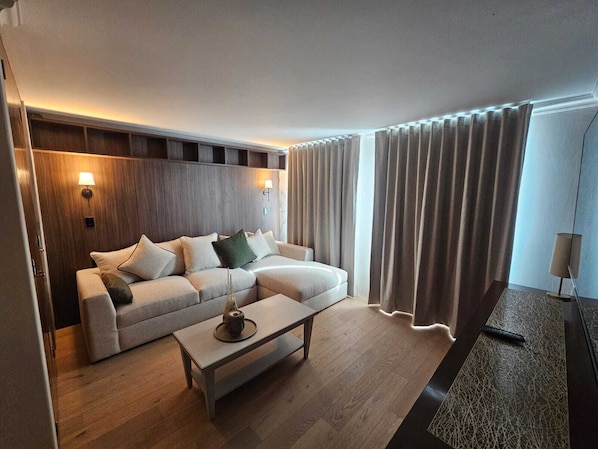 Habitación Deluxe | Área de sala de estar | Televisión de pantalla plana