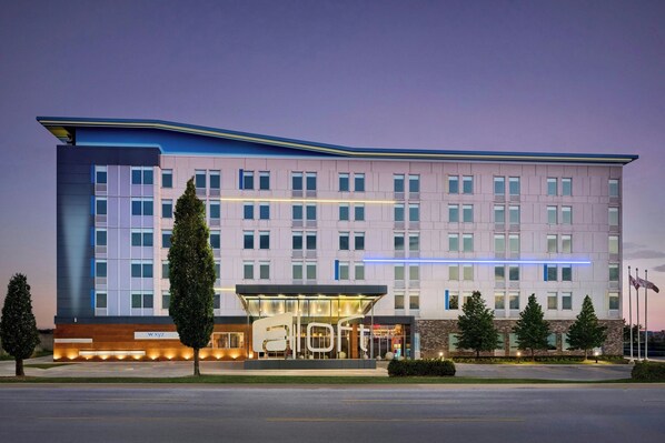 A modern hotel with a flat roof, large windows, and a glass entrance.