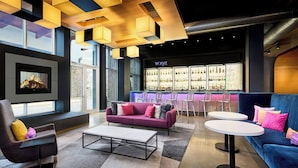 A modern lounge area with a bar, sofas, and a fireplace.