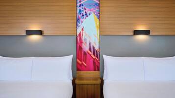Habitación de hotel con dos camas, cabecero de madera y un cuadro abstracto y colorido en la pared.