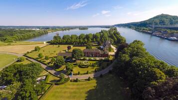 An aerial view of a large estate with a main building, multiple smaller structures, and a well-maintained garden.