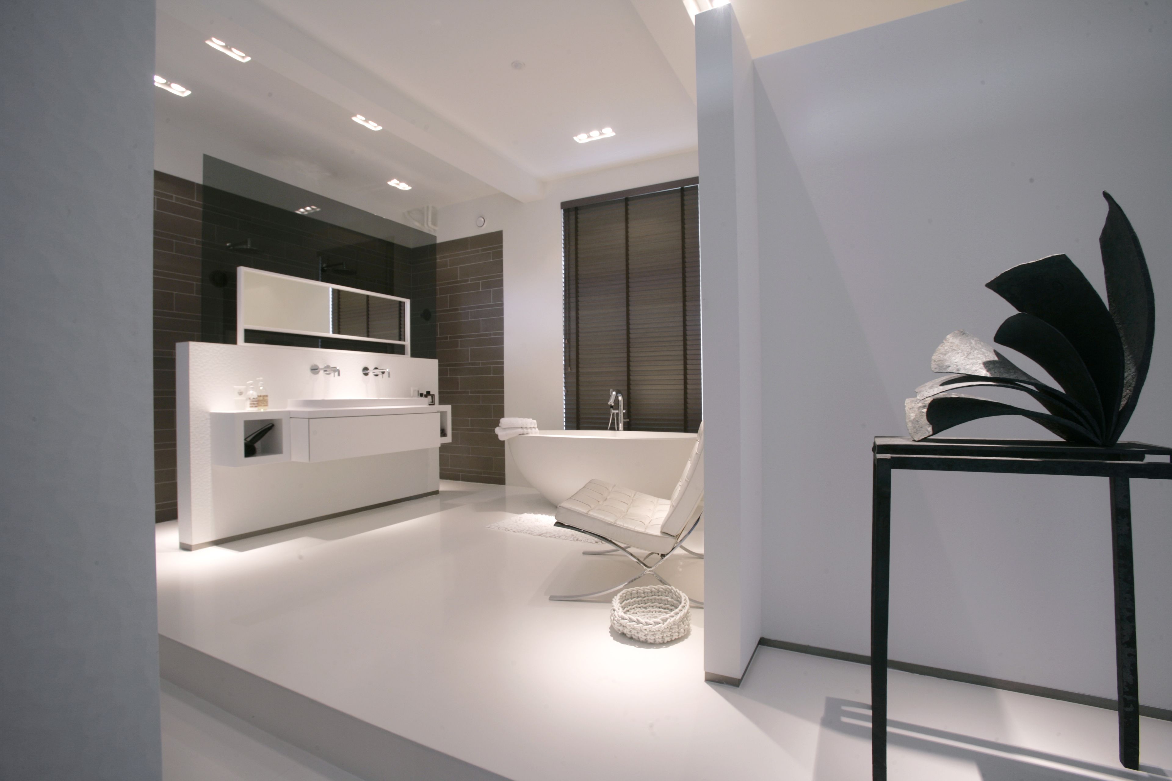 A modern bathroom with a freestanding bathtub, a vanity with a mirror, and a wall-mounted toilet.