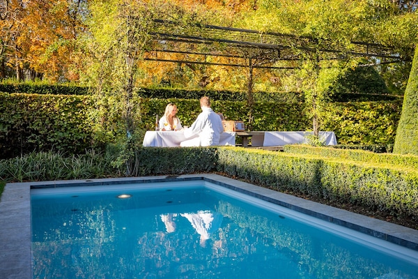 Una piscina al aire libre, sillones reclinables de piscina