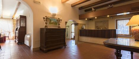 A spacious room with a wooden ceiling, a fireplace, and a dining table.