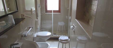 Egy fürdőszoba, amelyben WC, mosdókagyló és zuhanyzó található.