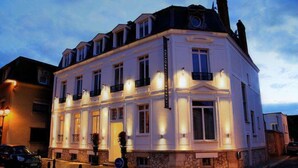 A historic building with a classic facade, multiple balconies, and a sign indicating it is a hotel. - Le Cesar Hotel (Provins)