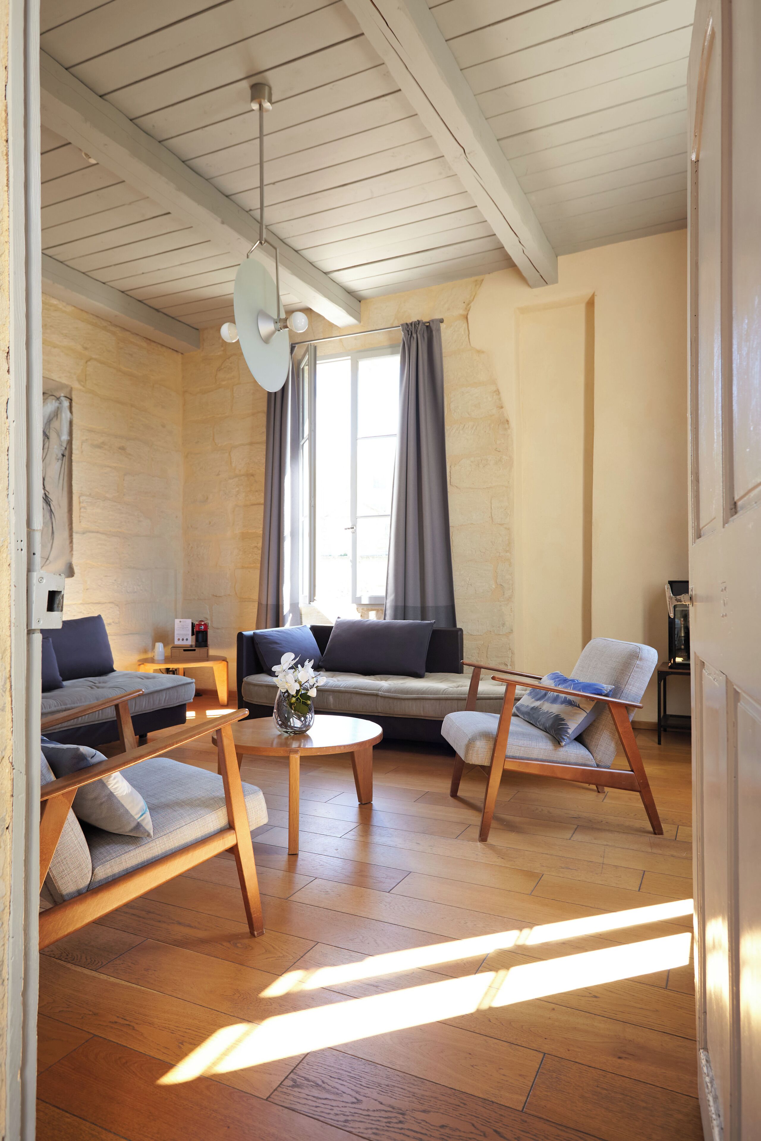 Uma sala de estar aconchegante com um sofá, poltronas e uma mesa de centro.