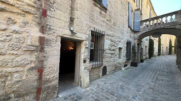 A stone building with a reception area, a cobblestone street, and a covered passageway.
