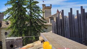 Una bandeja con comida y bebidas, una valla de madera y un castillo al fondo.