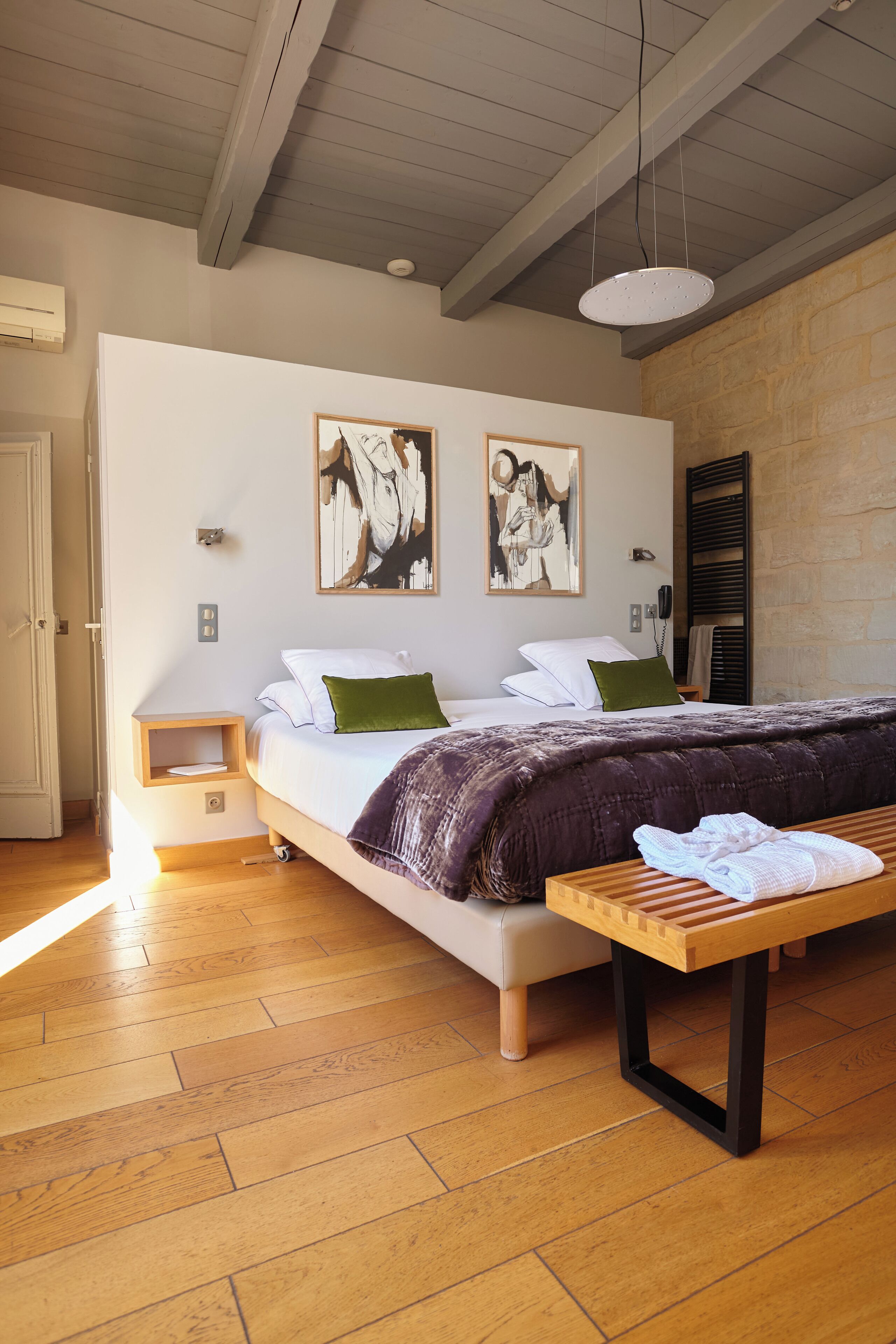 A bedroom with a bed, bedside table, and a bench.