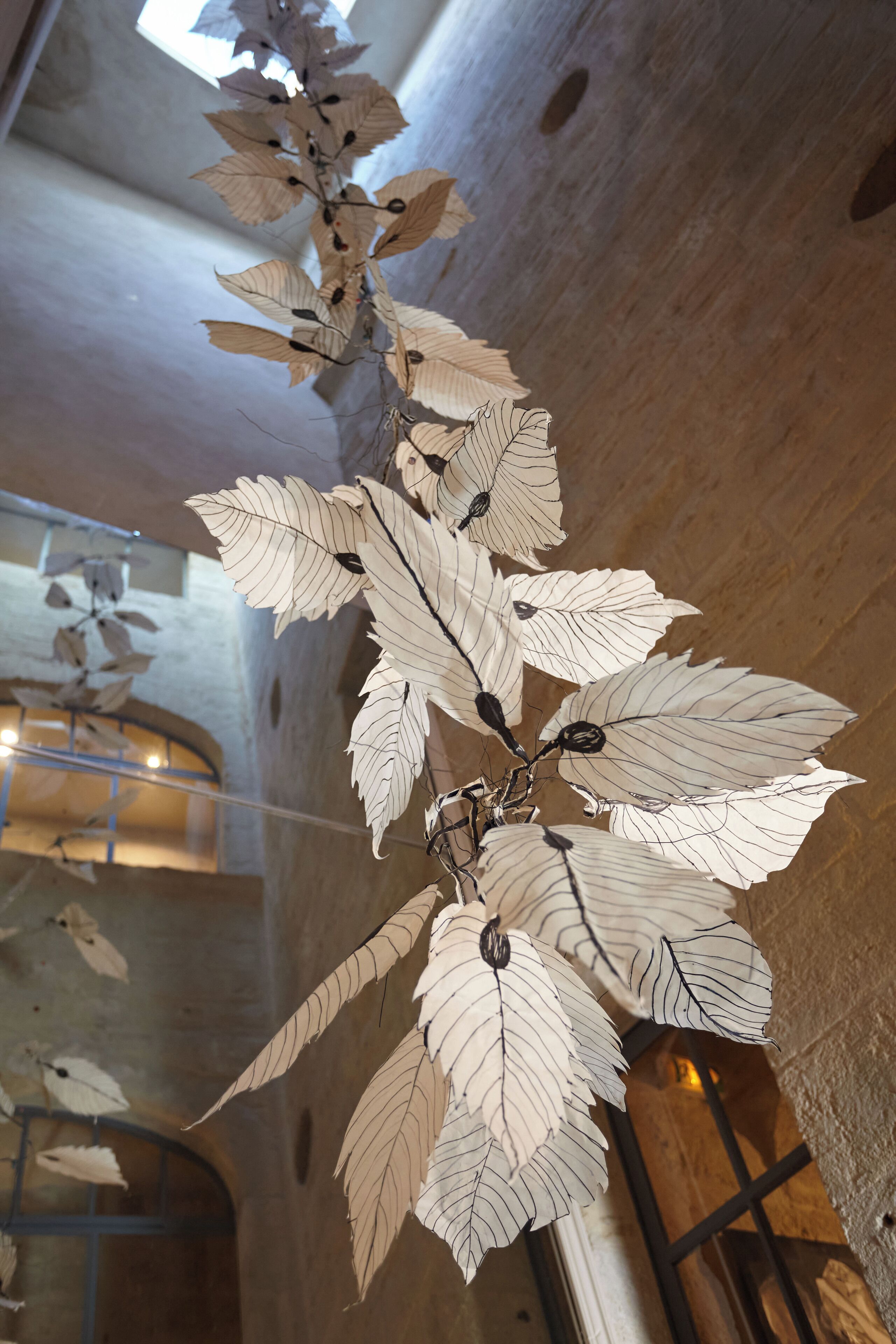 Decorazioni a forma di foglia pendono dal soffitto in un museo o una galleria.