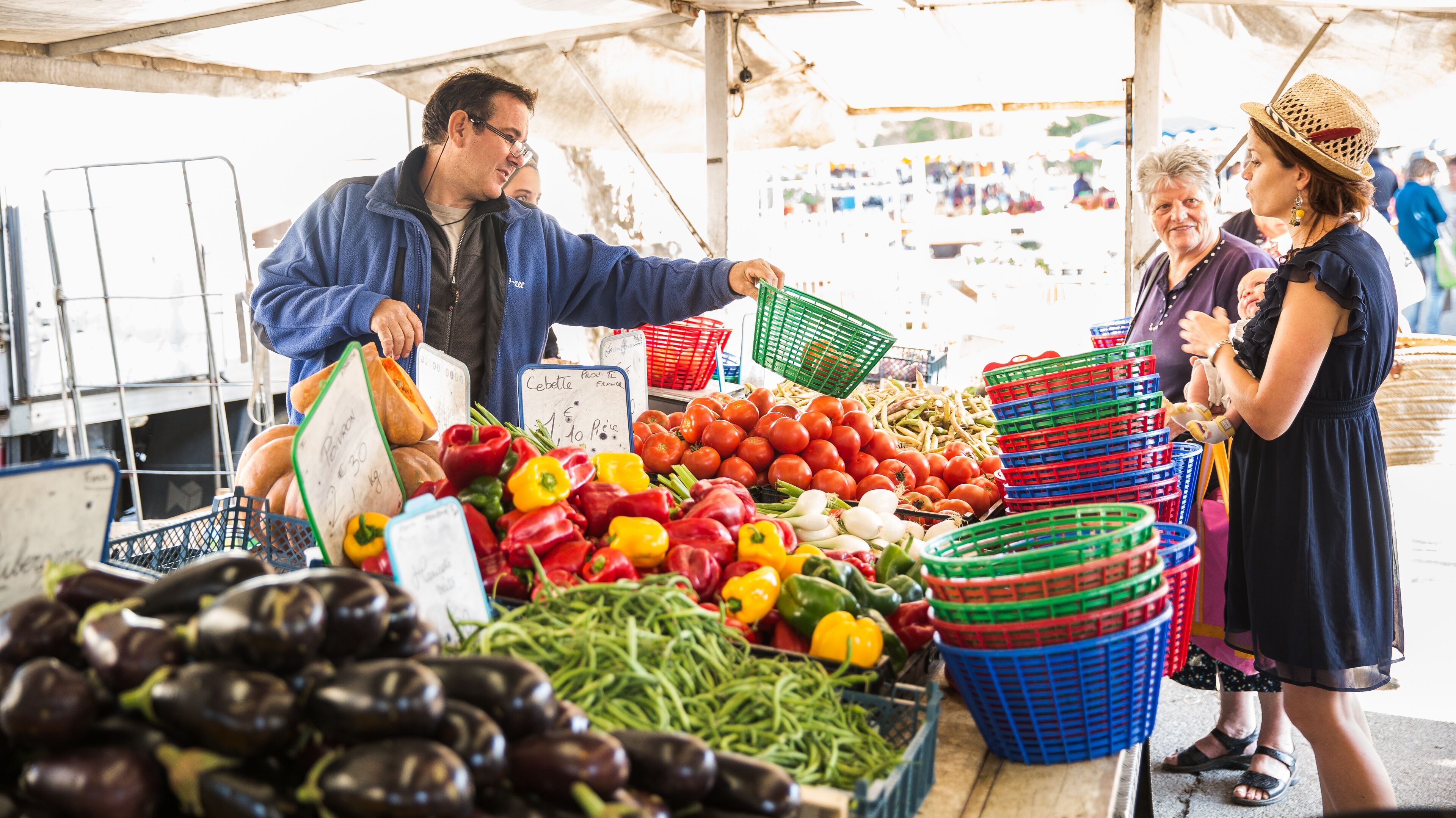 A market stall with fresh produce and baskets for customers.