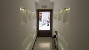 A hallway with a door leading to a room. There is a trash bin with an umbrella next to the door. - Hotel Plebiscito Aparthotel (Naples)