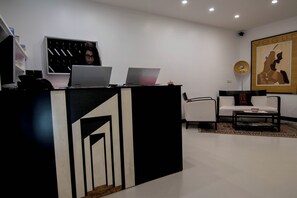 A reception desk with two laptops, a telephone, and a framed artwork on the wall. - Hotel Plebiscito Aparthotel (Naples)