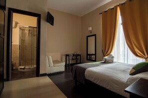 A hotel room with a bed, a sitting area, a shower, and a bathroom. - Hotel Plebiscito Aparthotel (Naples)