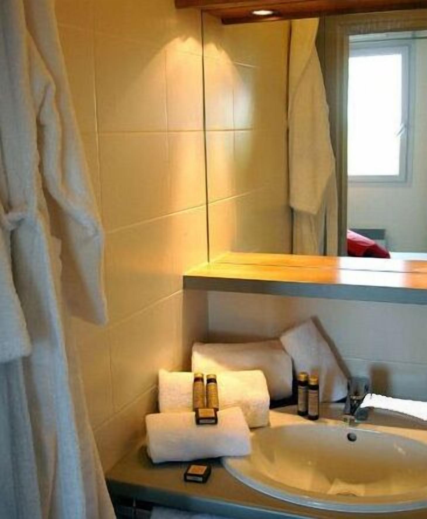 A bathroom with a sink, mirror, and towel rack.