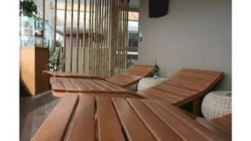 Un área de descanso moderna con bancos de madera y una pantalla de bambú.