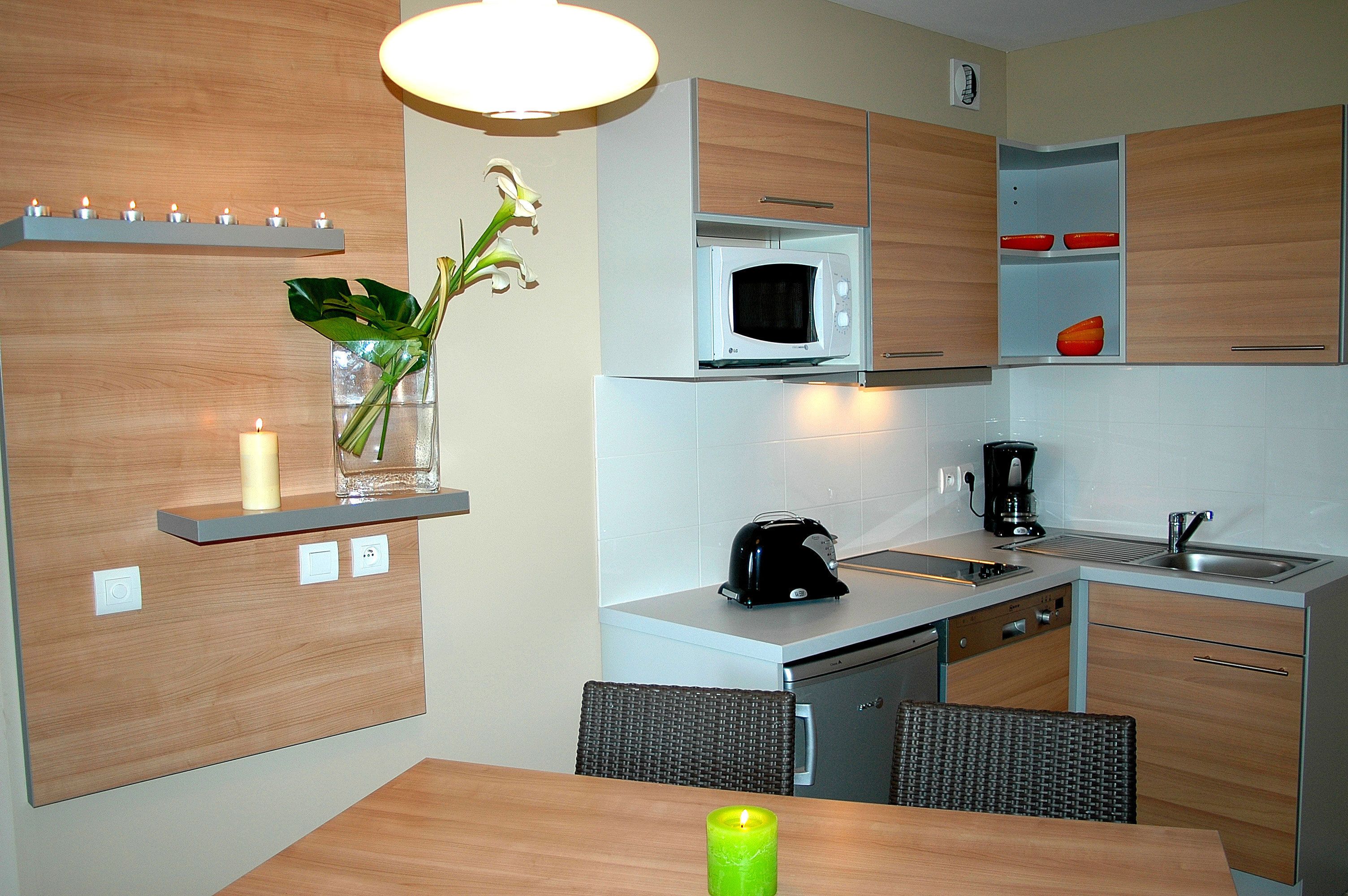 A modern kitchen with wooden cabinets, a microwave, a toaster, and a sink.