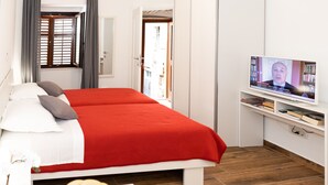 A hotel room with a bed, a TV, and a small table with fruit. - Apartments Santa Maria (Dubrovnik)