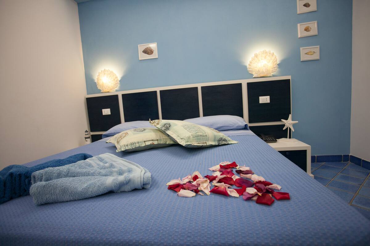 Habitación triple junior, vista al jardín (STELLA DI MARE) | Ropa de cama de alta calidad y caja de seguridad en la habitación