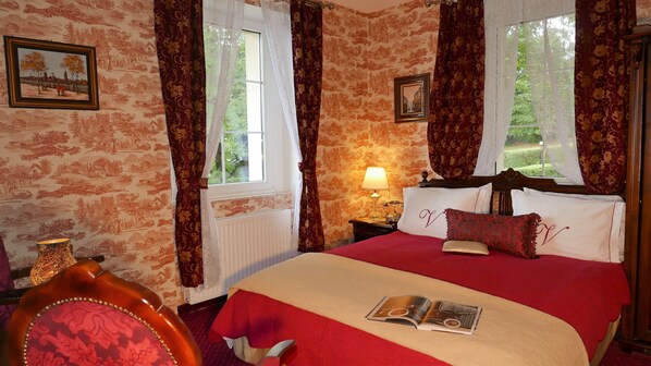 A room with a large bed, a nightstand with a lamp, and a window with curtains. - Rezydencja Grawert - Victorian Boutique & SPA (Ladek-Zdroj)