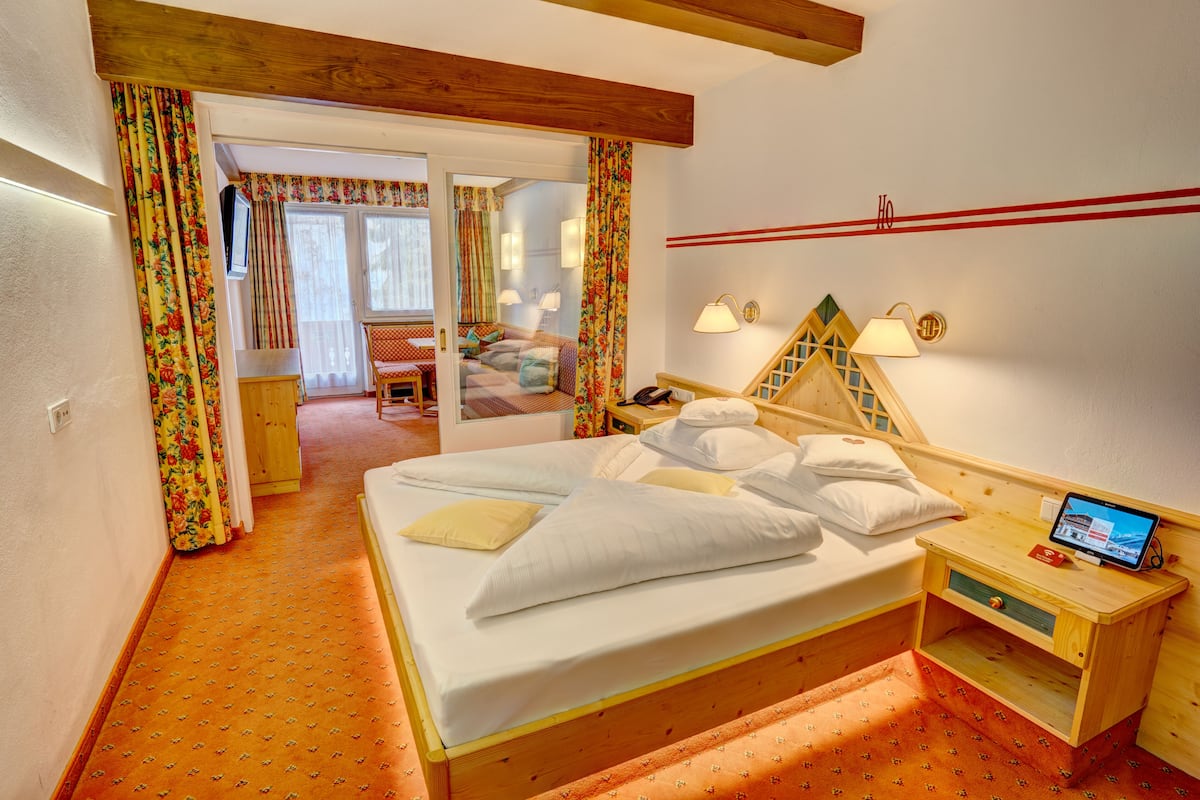 Une chambre à coucher avec un lit en bois, une table de chevet avec une lampe et un téléviseur.