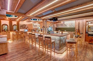 Un interior de madera con una zona de bar, sillas de madera y un piano.