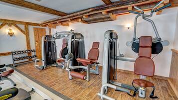 Et fitnesscenter med diverse træningsmaskiner, håndvægte og løbebånd.