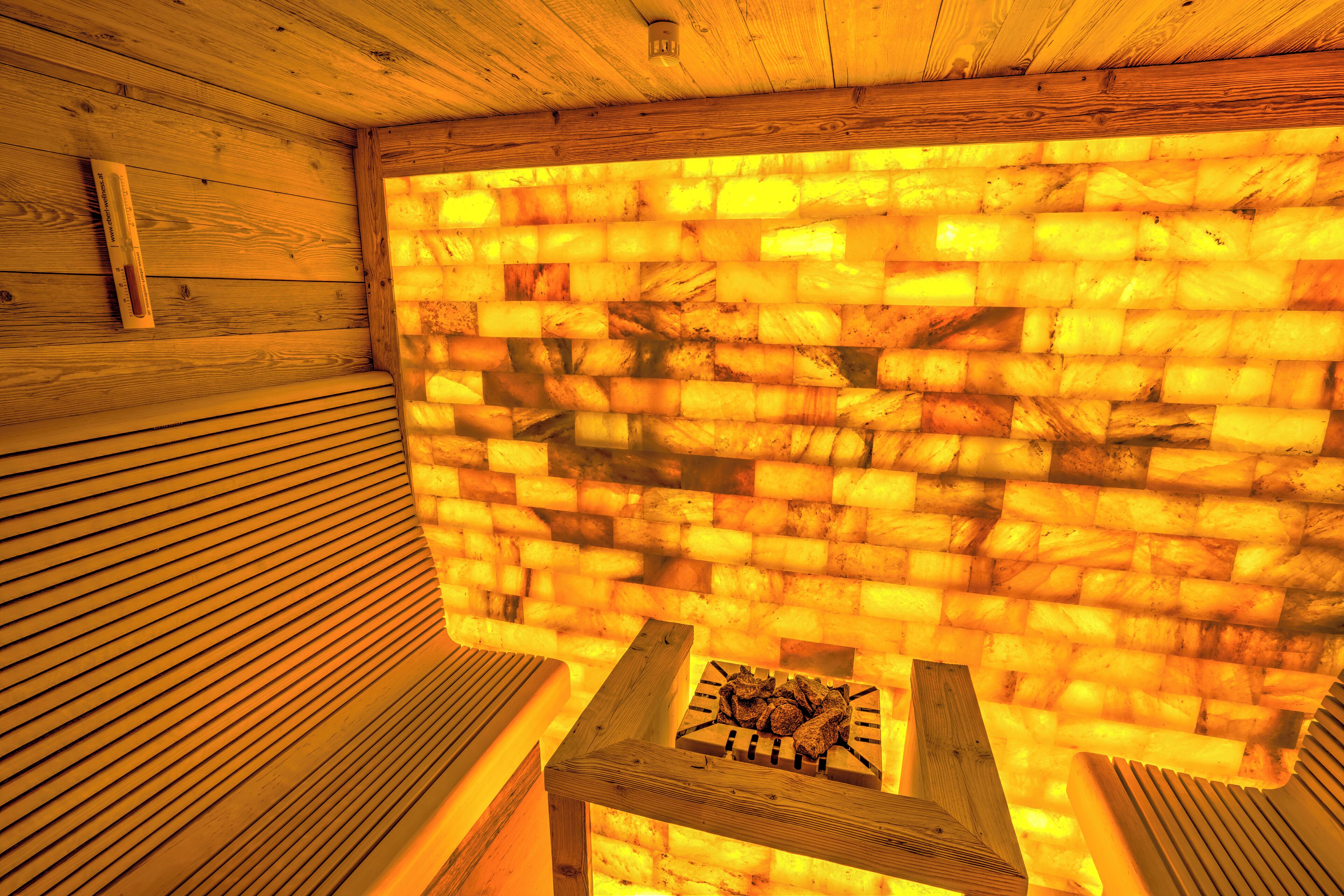 A sauna with a brick wall and wooden benches.
