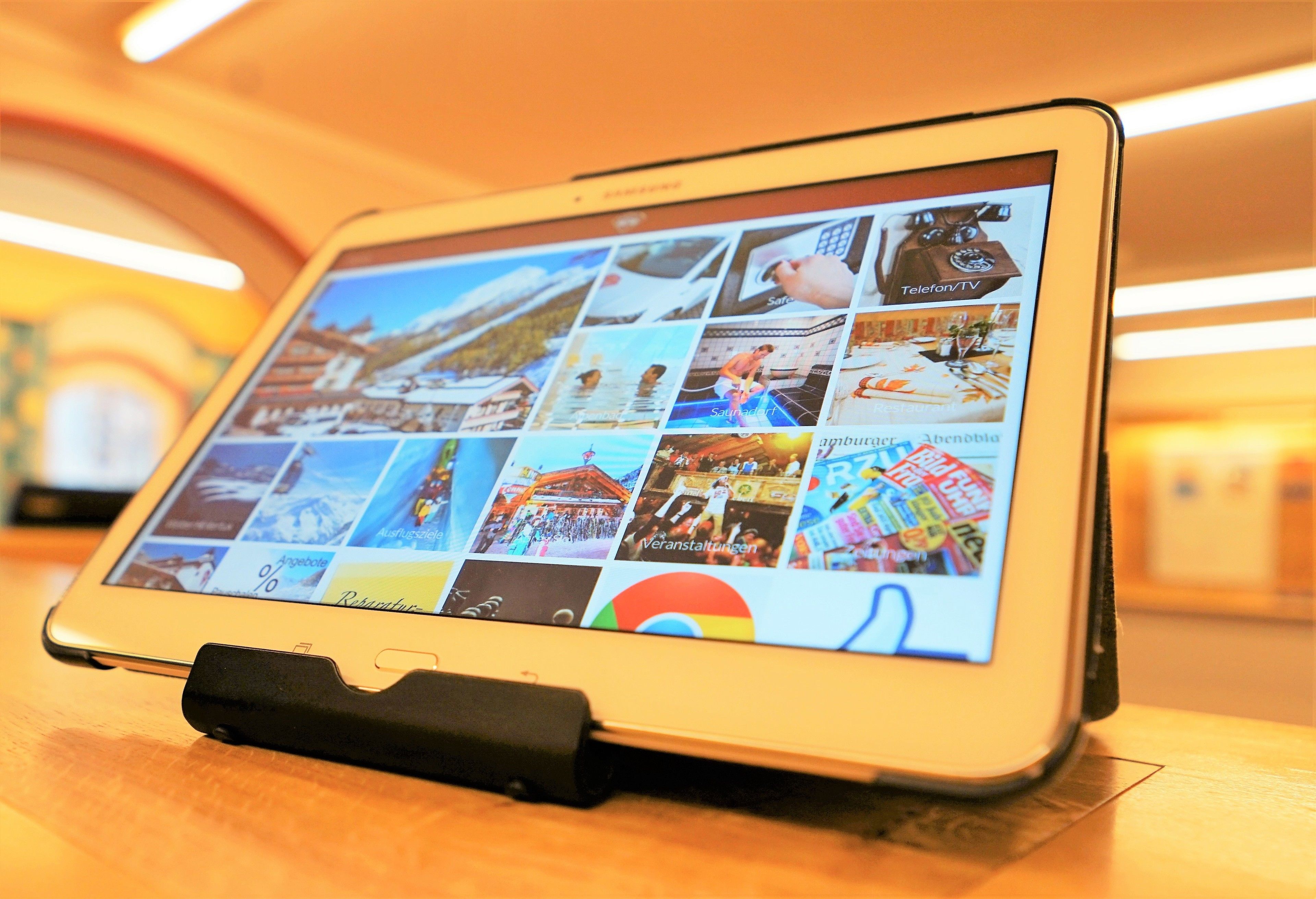 A tablet displaying a collage of images, likely for a hotel or travel-related application.