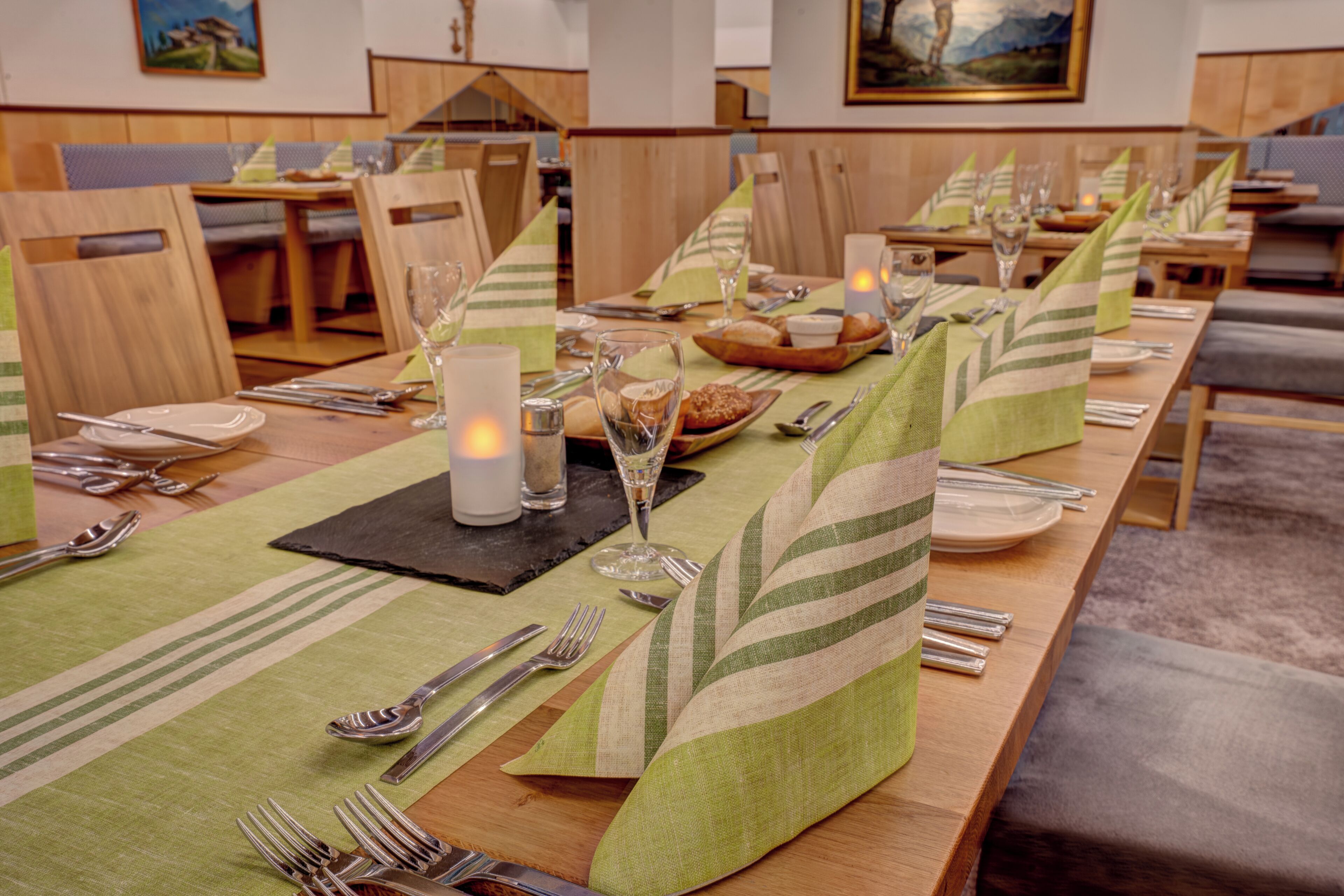Un comedor con mesas ordenadas, velas y vista al salón de comidas.