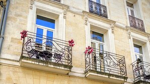 A multi-story building with balconies, a door with a number plaque, and bicycles parked in front. - Au cœur de Bordeaux B&B (Bordeaux)