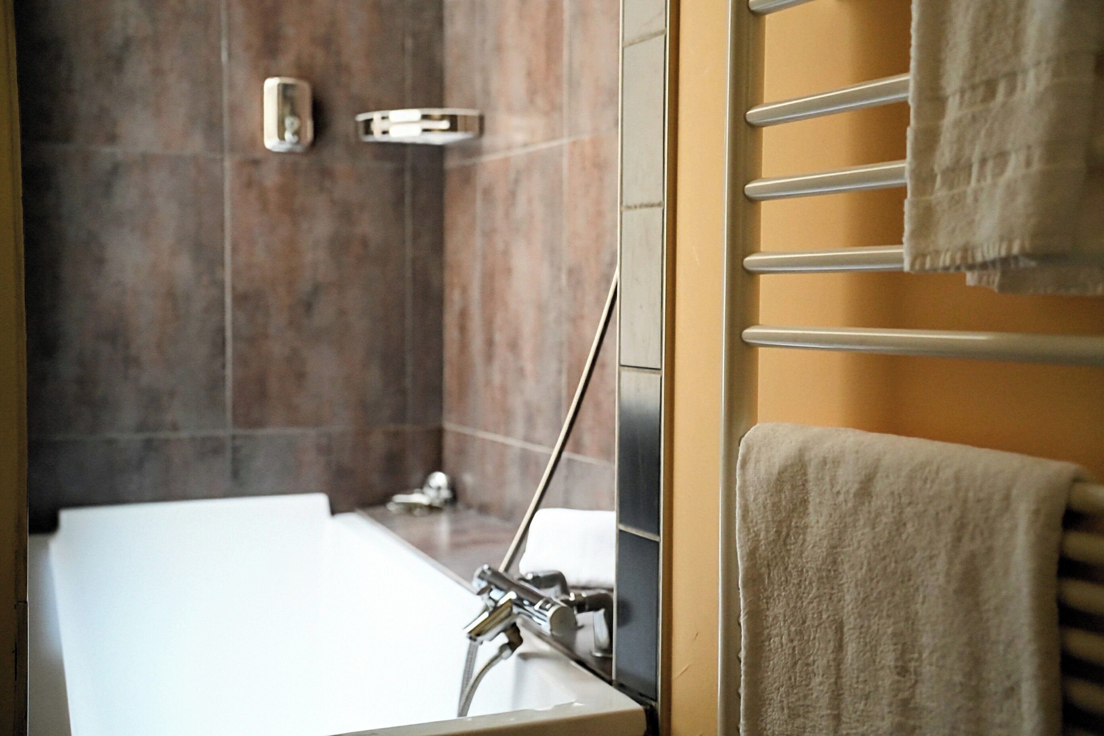 Un baño moderno con bañera, toallero y zona de ducha.