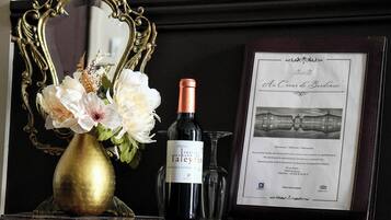 Un certificat encadré, une bouteille de vin et un vase rempli de fleurs, le tout posé sur une surface en marbre.