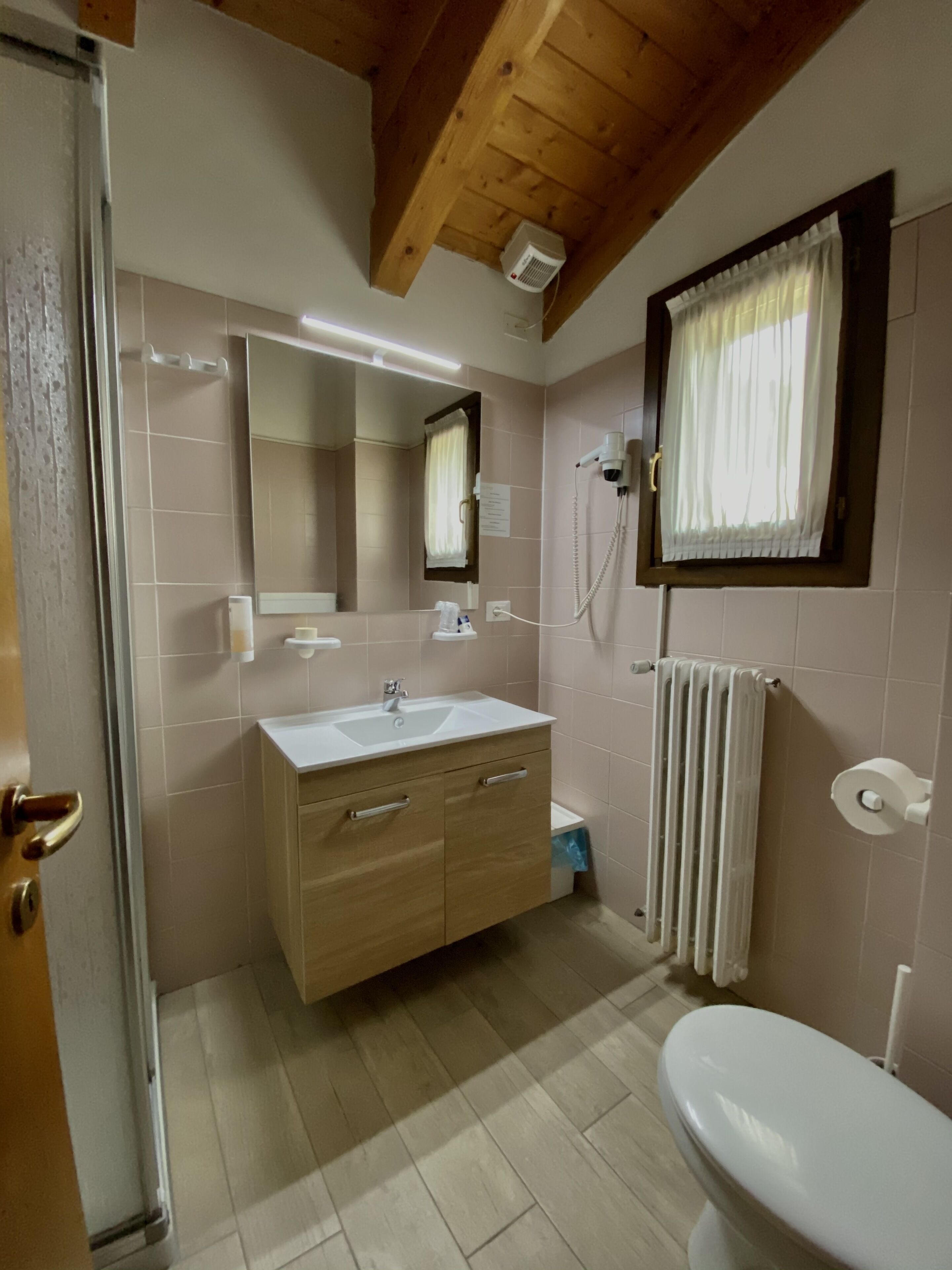 Une salle de bain avec un lavabo, un miroir et des toilettes.
