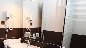 Un baño moderno con un lavabo blanco, un secador de pelo y un espejo.