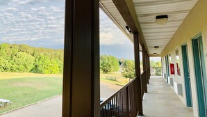 A covered outdoor area with a view of a green landscape and trees. - Weston Inn & Suites (Rusk)