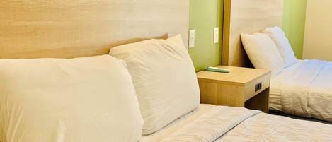 Quarto de hotel com uma cama, mesa de cabeceira e espelho.