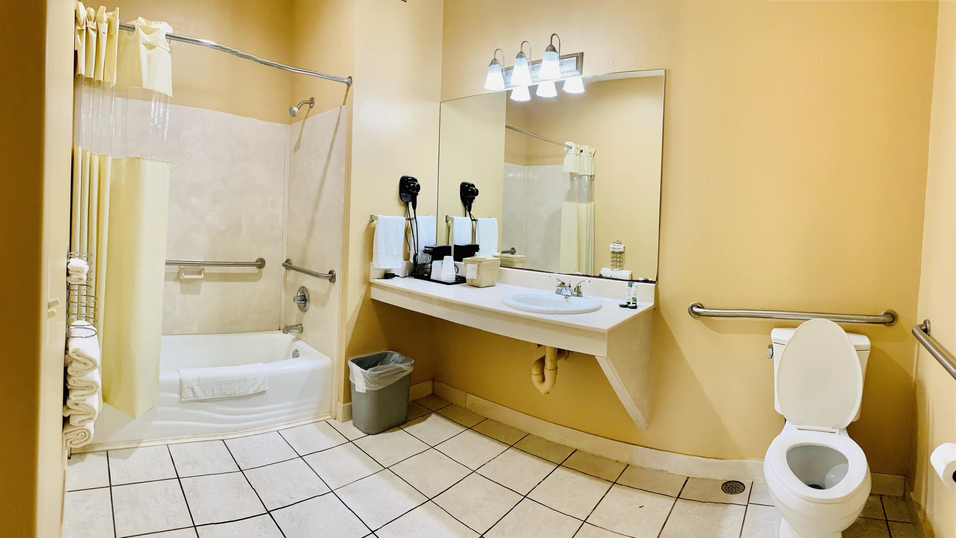 A bathroom with a bathtub, a toilet, a sink, and a shower area.