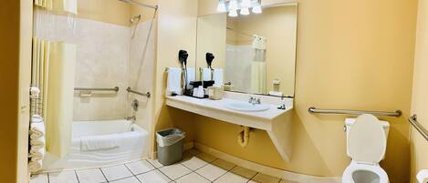 A bathroom with a bathtub, a toilet, a sink, and a shower area.