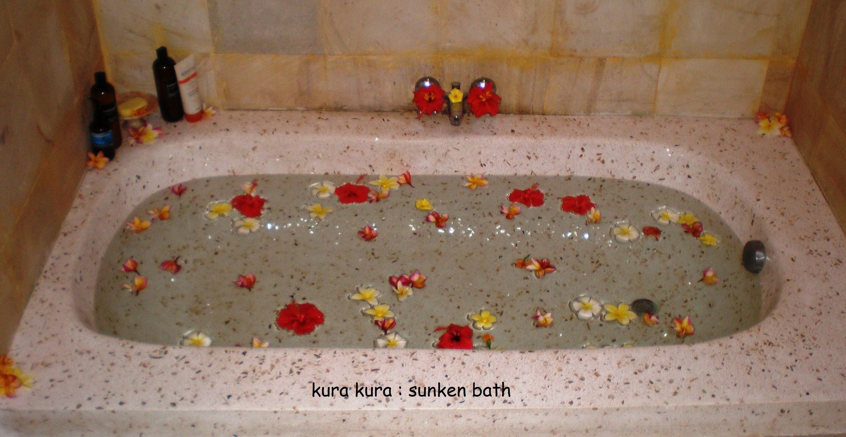 Una bañera llena de agua y flores flotando.