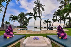 Una piscina al aire libre, sombrillas, sillones reclinables de piscina