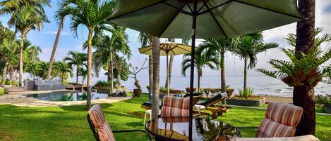 Un espace aménagé au bord de la piscine, avec des chaises longues, une table et des parasols.